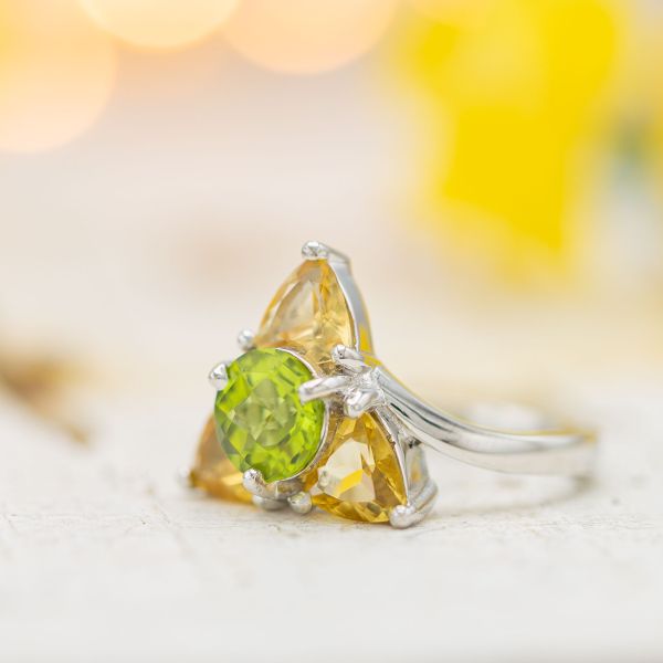 Triforce-inspired engagement ring with peridot and imperial topaz.
