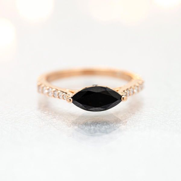 East-west set marquise onyx in a modern gold and diamond engagement ring.