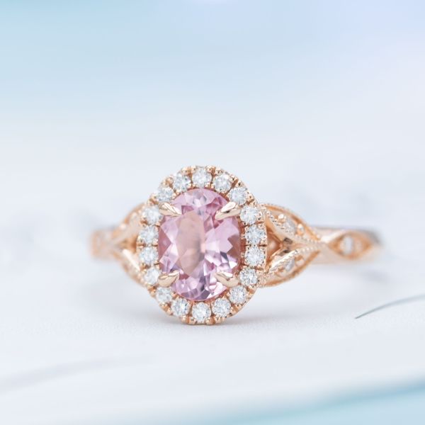 A beautiful halo engagement ring with diamonds surrounding the morganite center stone.