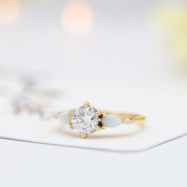 This engagement ring mixes diamond and white opal for a contrast of sparkle and subdued pastel color play.