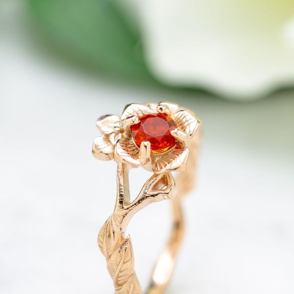 The intense orange of a fire opal makes the perfect center stone for this floral rose gold ring.