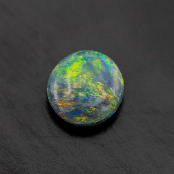 Black opal with intense green, yellow and orange color play.
