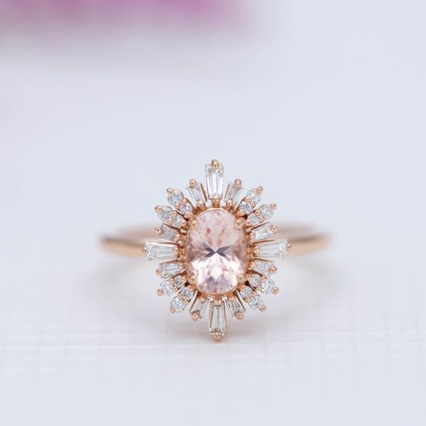 This morganite engagement ring surrounds the center stone with a bold, ballerina halo of baguette diamonds.