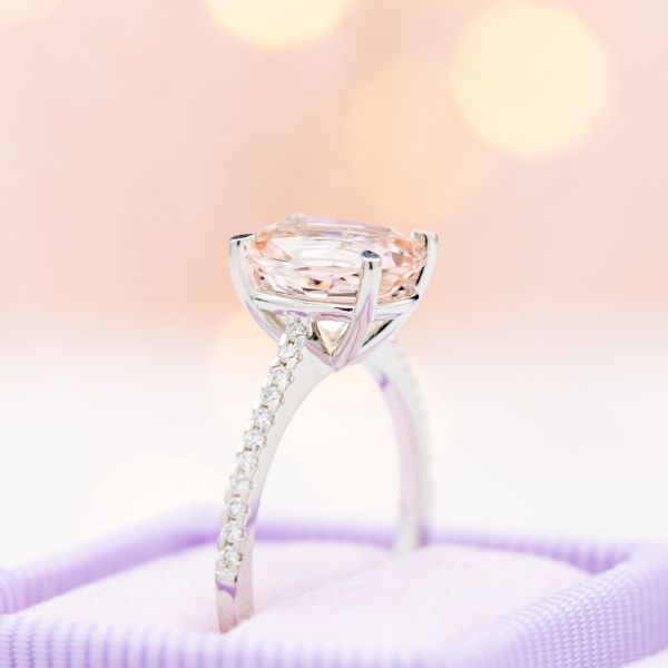 This morganite engagement ring sets the oval center stone with a sleek, contemporary prong setting to allow tons of light onto the center stone.