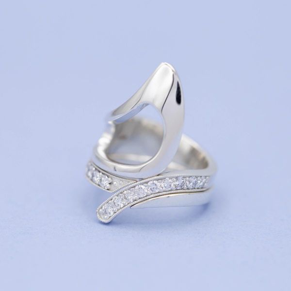A bold, curving no-stone engagement ring with a perfectly fitted cuff-style wedding band.