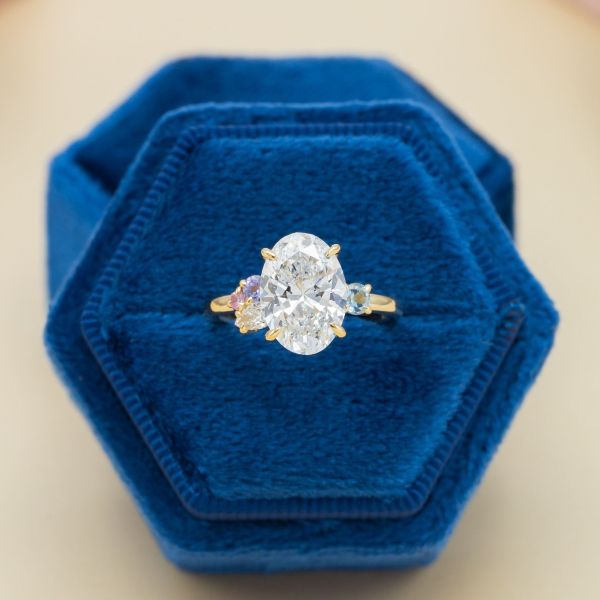 This bright white lab diamond is a stunner at the center of this asymmetrical cluster engagement ring.