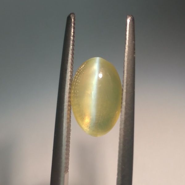 Cat's eye chrysoberyl shows a distinctive line across its shimmering surface.
