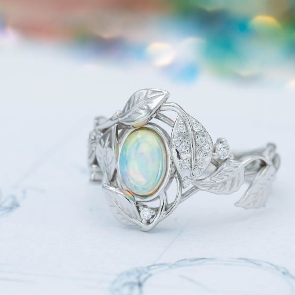 The cool blues and greens of this white opal are the perfect center stone for a nature-inspired engagement ring.