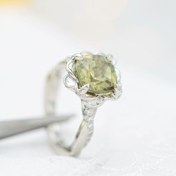 White gold flower engagement ring featuring a rare zultanite center stone.