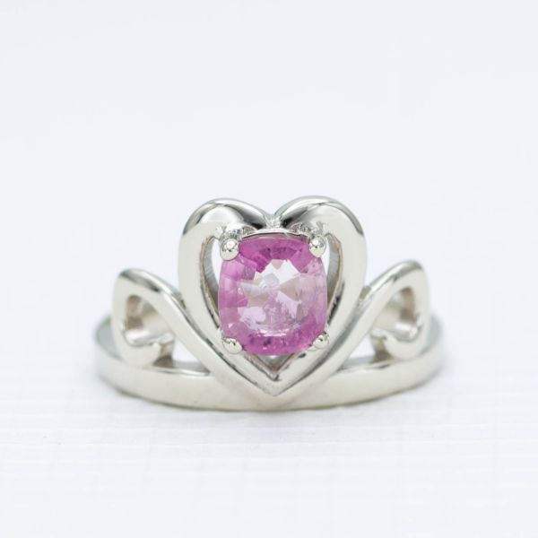 A tiara-inspired promised ring in white gold with a cushion cut poudretteite center stone.