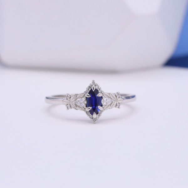 A blue, marquise cut lab sapphire engagement ring.