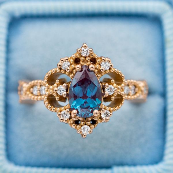 Vintage engagement ring in rose gold with a pear cut alexandrite and diamond accents.