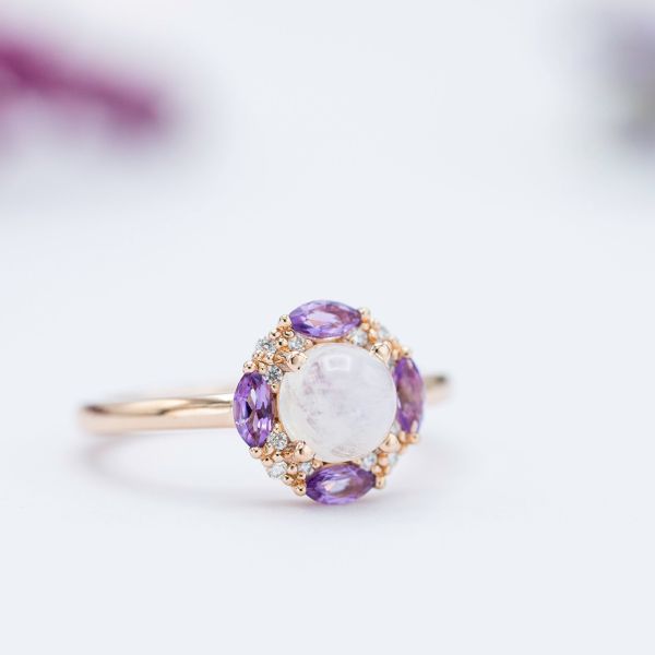 Moonstone engagement ring with a unique halo of marquise amethysts and diamonds.