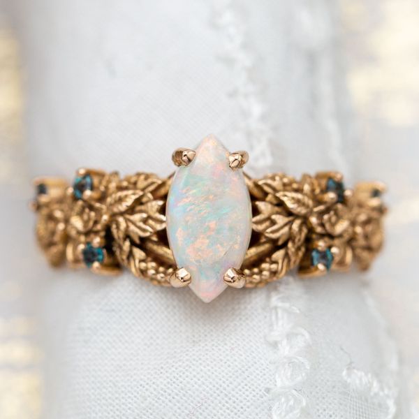 This ring's intricate nature-inspired detail serves as a backdrop to the opal's bright colors.