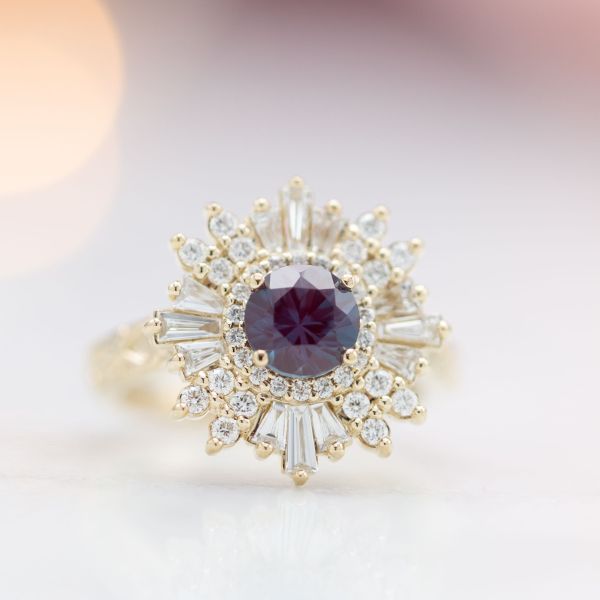 A bold combination of baguette and round halo stones create a ballerina halo around this alexandrite center stone.