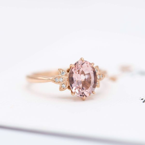 The finished morganite engagement ring created from the sketches above, with a bright burst of diamonds around the oval center stone.