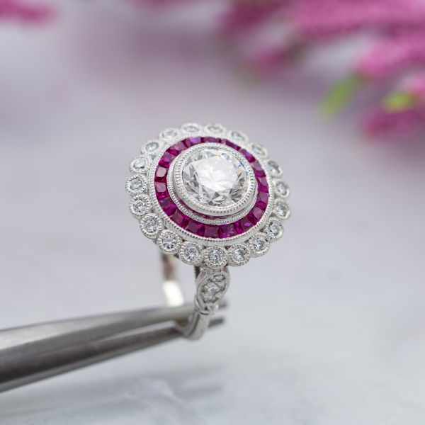 A classic Art Deco-inspired halo ring with calibré-cut rubies forming a perfect inner halo.