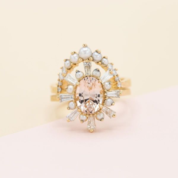 A stunning ballerina halo of diamonds and pearls surrounds a morganite centerstone, paired with an arcing graduated pearl wedding ring.