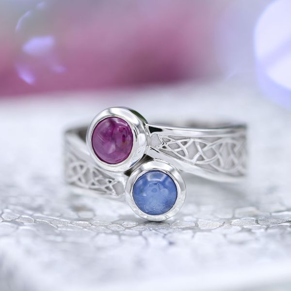 A unique two-stone setting with cabochon cut sapphires and Celtic knot detailing.