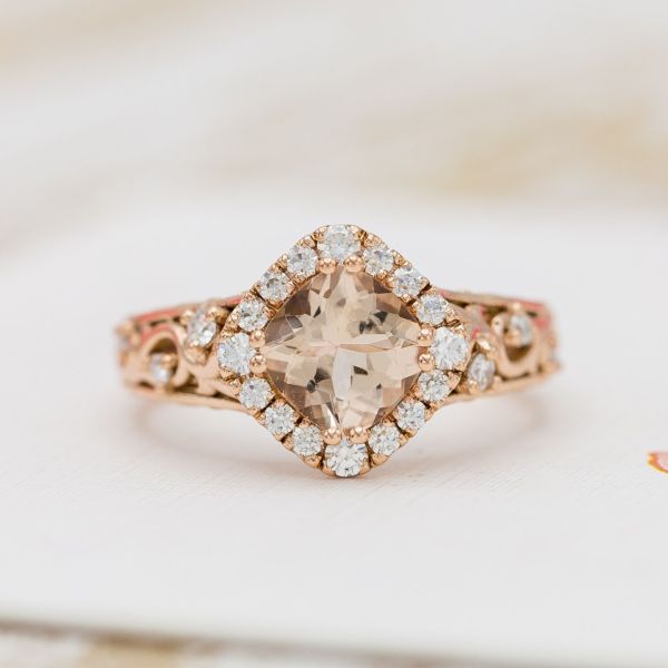 A stunning champagne peach morganite serves as the centerpiece of this rose gold engagement ring.