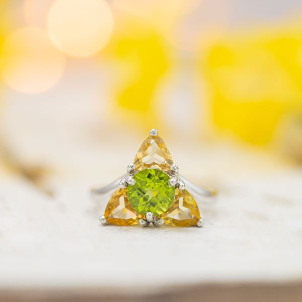 A unique Triforce-inspired engagement ring with precious topaz and peridot creating the Zelda-inspired triangular setting.