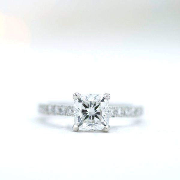 A clean, timeless cushion cut diamond solitaire engagement ring.