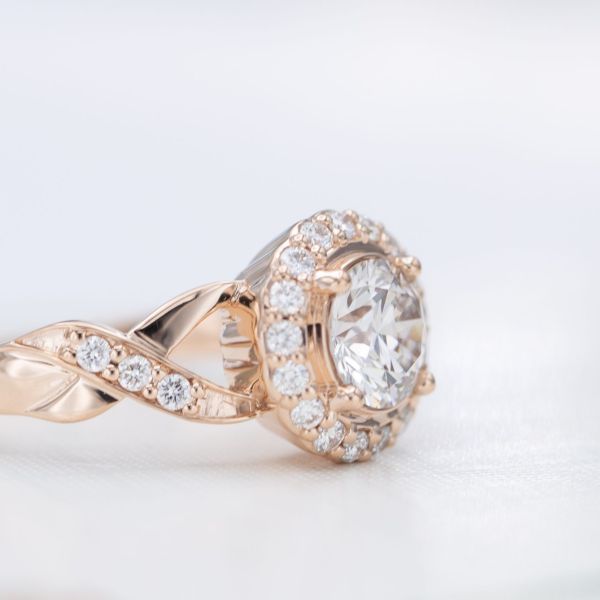 This ring's halo slopes away from the center stone for a more understated setting.