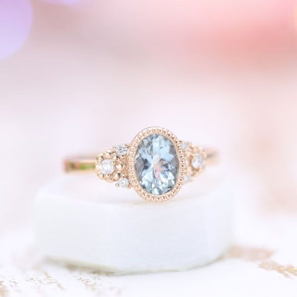 This oval cut aquamarine is set in yellow gold with touches of diamond accents.