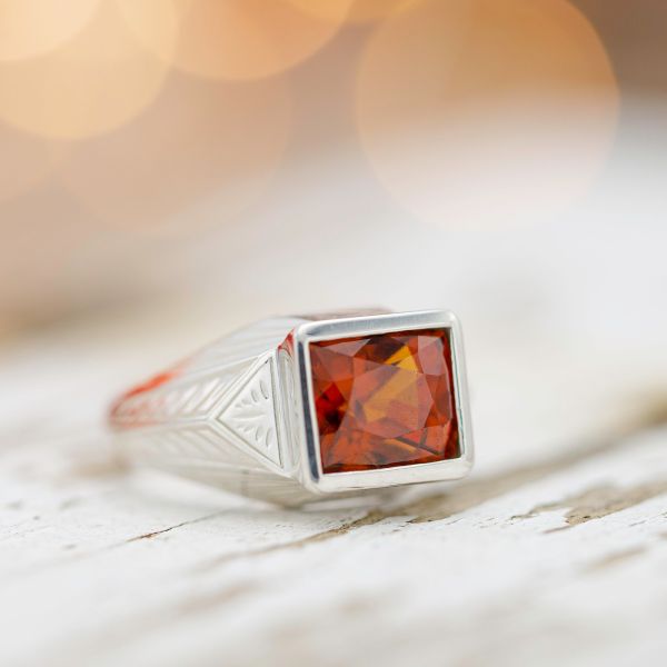 A bold, Art Deco-inspired ring with a fiery orange hessonite garnet center stone.