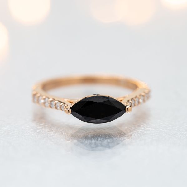 An east-west setting for this onyx center stone stretches the marquise gem across the finger for a distinctive, modern look.