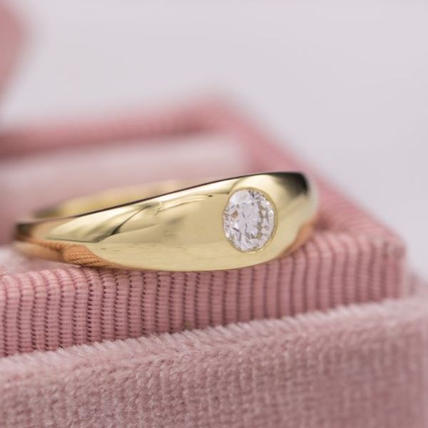 This diamond is flush set into the curvy gold shank of the ring.