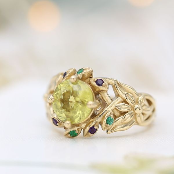 Chrysoberyl engagement ring with a floral theme and emerald and amethyst accents.