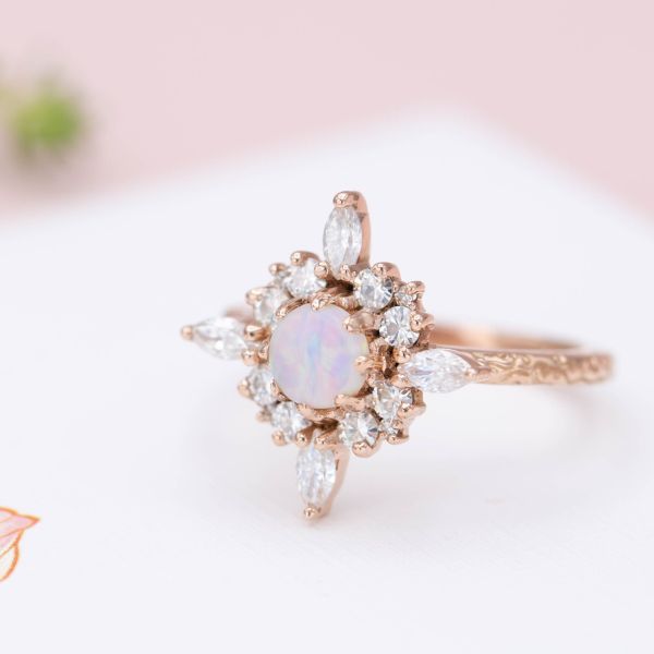 A unique halo extends like the star of Bethlehem around this ring's smaller opal center stone.