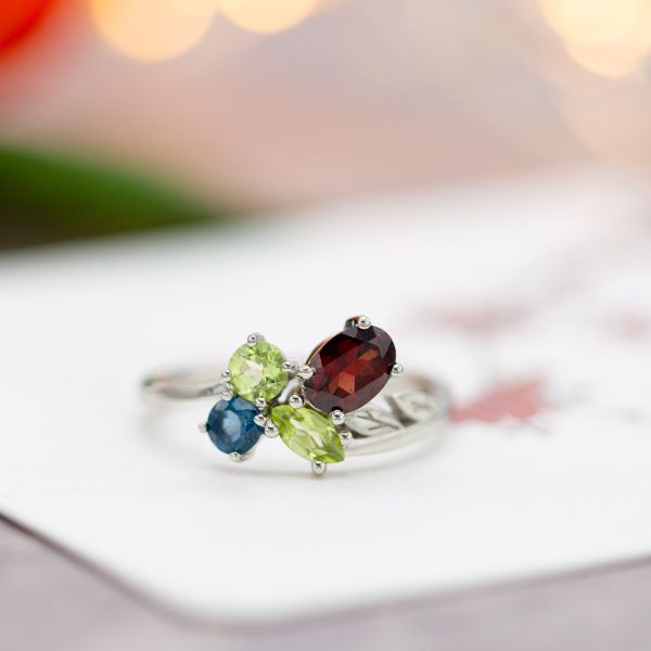 A modern asymmetrical cluster ring with red garnet, peridot and topaz.