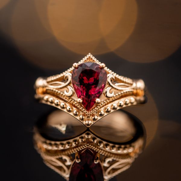 A breathtaking, vintage-inspired bridal set in rose gold features a uniquely deep red tourmaline.