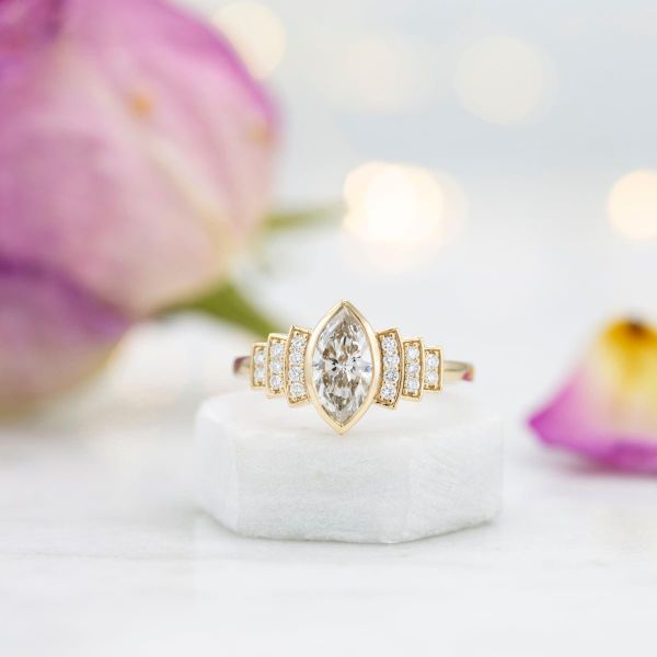 一枚侯爵钻石订婚戒指，装饰风格的弧形强调钻石辐射沿乐队。
