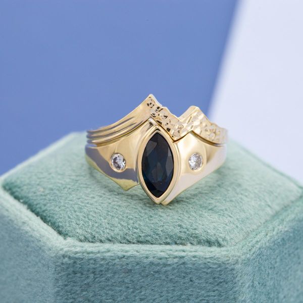 一个蓝宝石新娘套装，宽，弯曲的戒指，平齐的钻石，和一个山灵感的合适的结婚戒指。