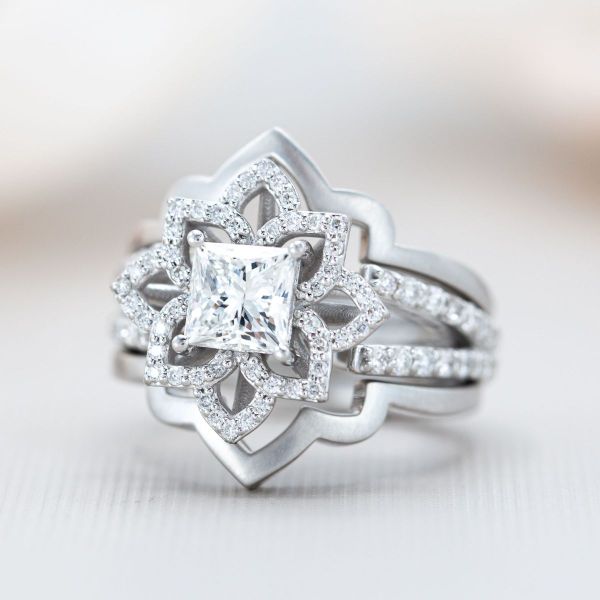 A princess cut diamond sits in the center of this mandala shaped bridal set.