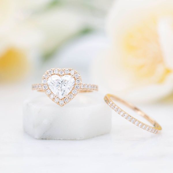 Diamonds sparkle in a halo that matches the heart cut diamond shining inside this engagement ring.