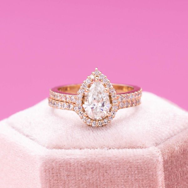 This lab created pear cut diamond ring shines brightly with a sparkling halo and a peekaboo butterfly.