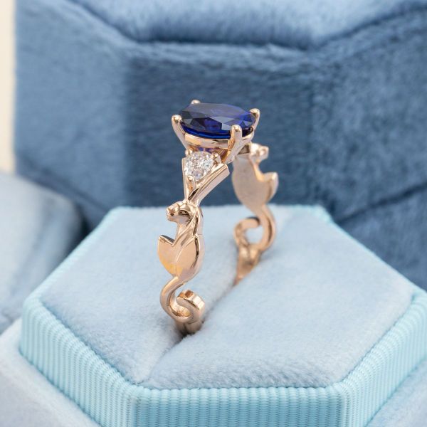 This lioness inspired yellow gold band features an oval cut blue sapphire  center stone for this engagement ring
