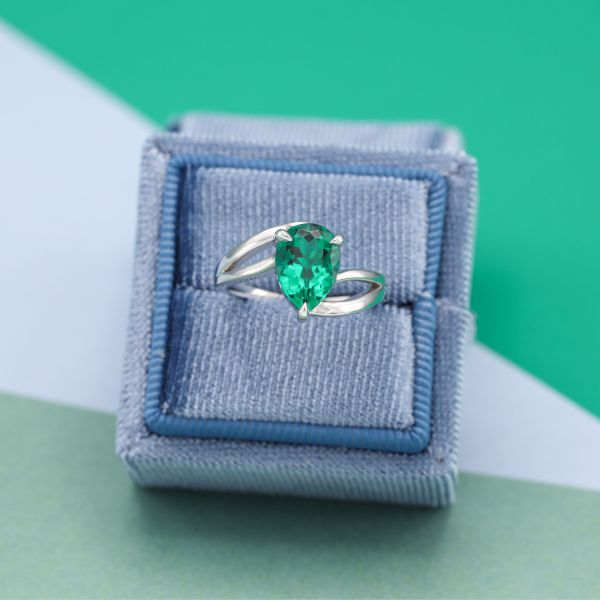 Sweeping white gold holds this pear shaped emerald.