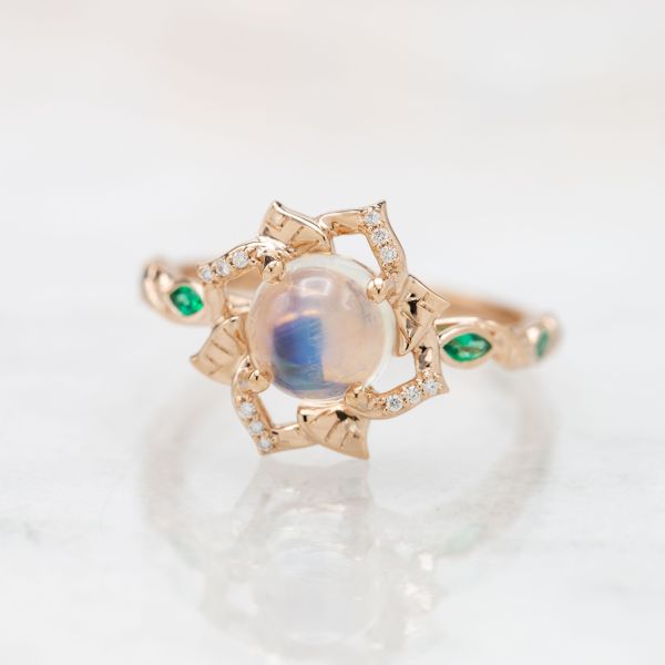 A perfectly delicate design in rose gold creates an open flower-petal frame for the ethereal moonstone at its center.