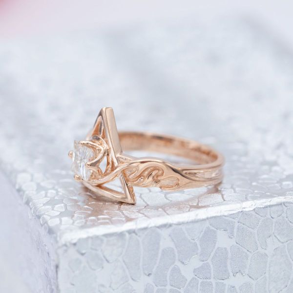 This vintage-styled engagement ring features a deathly hallows inspired symbol on the front and buck antler patronus charm inspired symbols on the band.