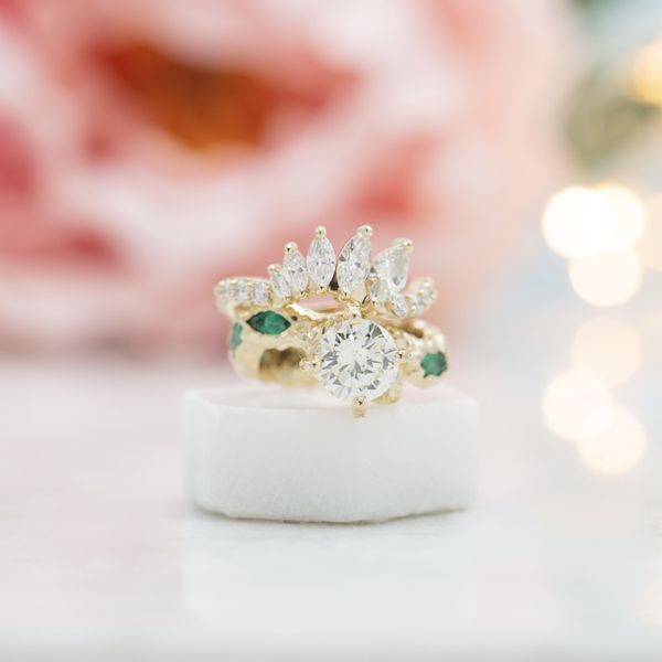 Emeralds and diamonds act as scales in this snake inspired engagement ring design.