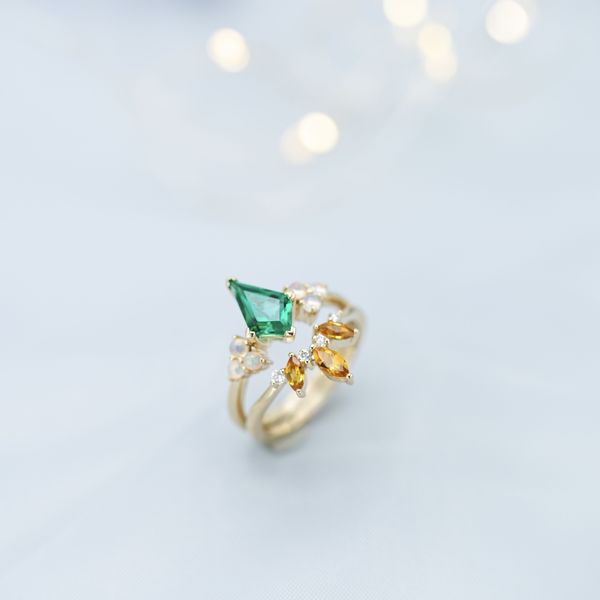 Kite-cut emerald, opals, citrines, and diamonds work together on this yellow gold bridal set.
