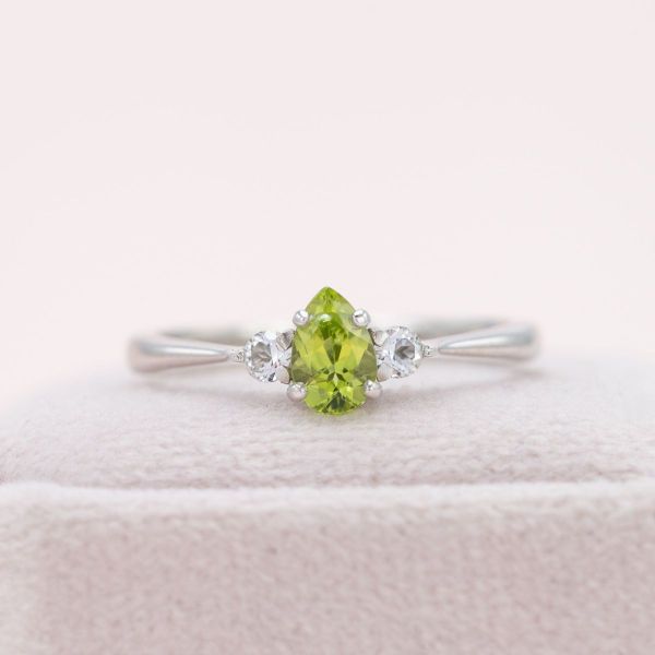 Mountain peaks are brought to life by this pear cut peridot and white topaz engagement ring.