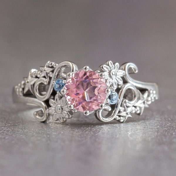 在这款异想天开的星星和花朵戒指设计中，一对经过处理的浅粉色黄玉配以海蓝宝石，为戒指增添了明亮的色彩。