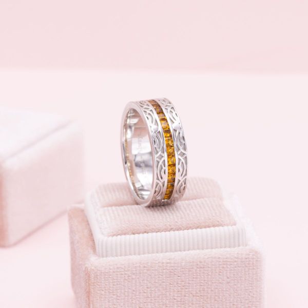 A channel of blazing citrine fire smolders at the center of this magical Celtic white gold band.