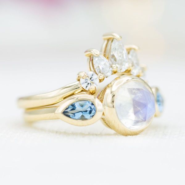 The blue tones of this rose cut moonstone combine perfectly with aquamarine side stones to create this unique engagement ring.